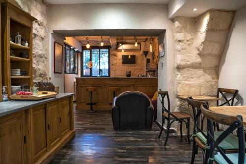 un restaurant avec un bar doté de chaises et de tables dans l'établissement Hôtel La Muette, à Arles
