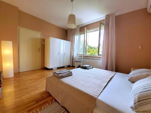 a bedroom with a large bed and a white refrigerator at Sunny Central Apartment in Sofia