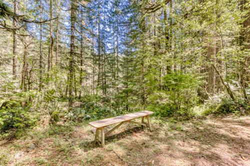 a wooden bench sitting in the middle of a forest at Huckleberry Haven in Rhododendron