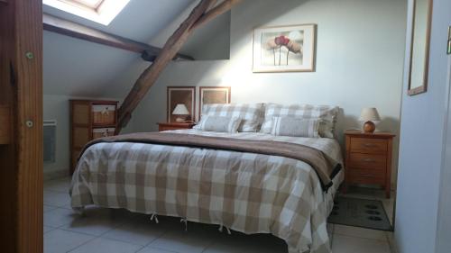 a bedroom with a bed with a checkered blanket at La Joie du Muguet Detached cottage Private heated swimming pool Shared Games room in Auverse