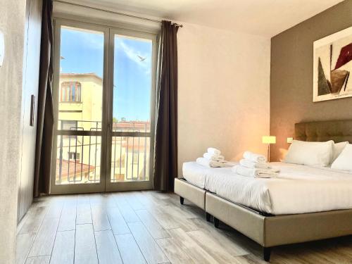 フィレンツェにあるBorgo Guelfo Iのベッドと大きな窓が備わるホテルルームです。