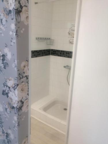 La salle de bains est pourvue d'une baignoire et d'un rideau de douche. dans l'établissement Maison de Vacances Cronat - Au Bord de l'EuroVelo 6, à Cronat