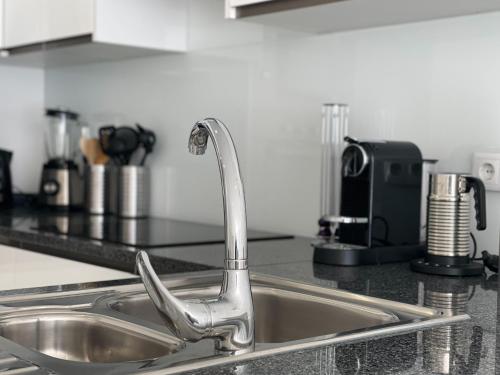 a kitchen sink with a faucet on a counter at Casa Rosa - Vilamoura in Vilamoura