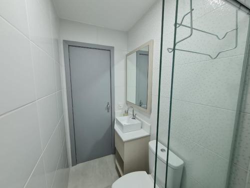 La salle de bains est pourvue de toilettes, d'un lavabo et d'une douche. dans l'établissement Belo Apartamento Eldorado II Master Collection, à Passo Fundo