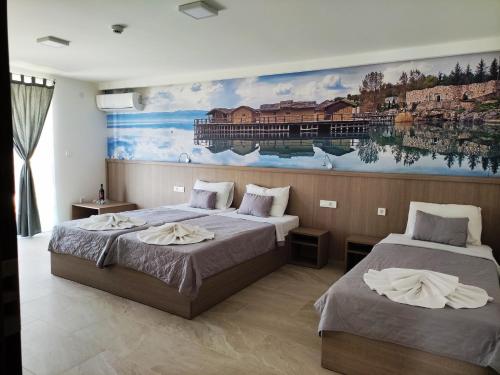 two beds in a room with a painting on the wall at Villa Sv. Stefan in Ohrid
