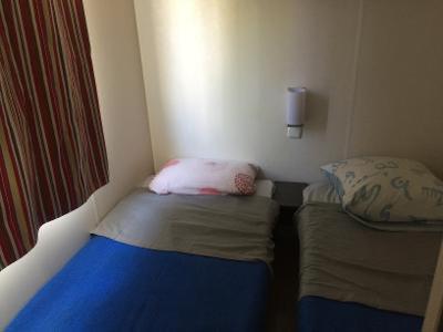 una piccola camera con due letti e una finestra di MOBIL HOME Climatisé 6 Personnes au Camping Marvilla Parks - Le Parc Des Septs Fonts ad Agde