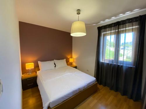 a bedroom with a white bed and a window at Apartments Braje in Rabac