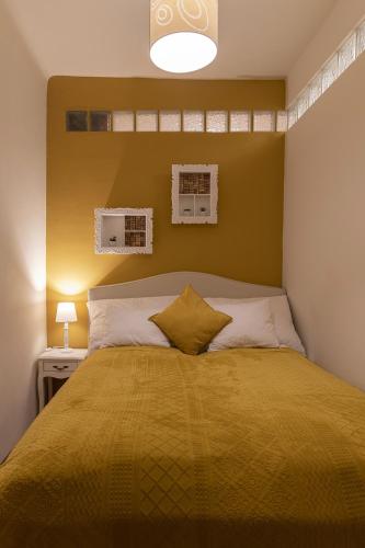 a bedroom with a large bed with a yellow bedspread at Cork Apartman in Eger