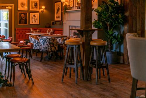 a bar with tables and stools in a restaurant at The Langford Inn in Langford
