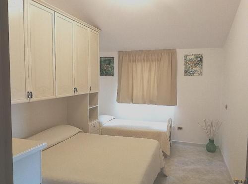 a small room with two beds and a window at Villa Arenella in Vieste