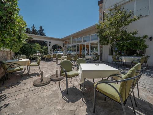 a group of tables and chairs in front of a building at Mediterranean Guest House Balkan in Budva