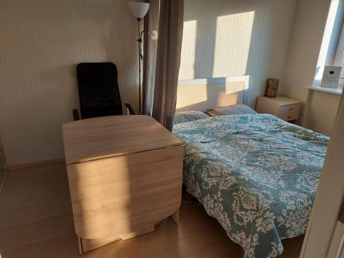 ein Schlafzimmer mit einem Bett mit einer Kommode und einem Stuhl in der Unterkunft Cosy Apartment in Klaipėda