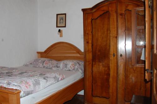 a bedroom with a bed and a wooden cabinet at Balajceva domačija - Moravske Toplice in Moravske Toplice