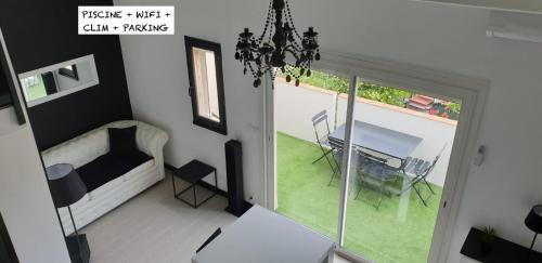 a living room with a bed and a table and a window at T2 Bis Design et Lumineux à 200m du Village Naturiste in Cap d'Agde