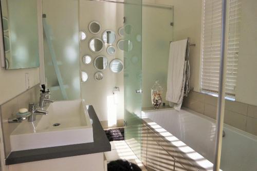 a bathroom with a sink and a bath tub and a sink at Immaculate 3 Bedroom Apartment Available In Durban Musgrave Area. in Durban