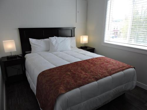 a bedroom with a large bed with a red blanket at Almo Court Motel in Cranbrook