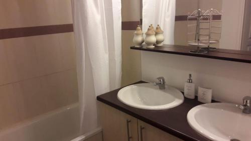 um banheiro com duas pias e uma banheira em Appartement 2 chambres Balcon Parking privé Centre Village em Lit-et-Mixe