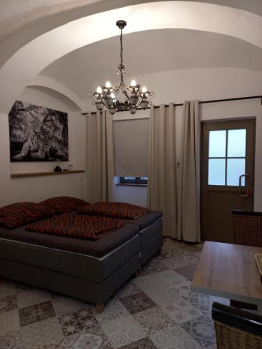 a living room with a couch and a chandelier at A-M Condominium in Veszprém