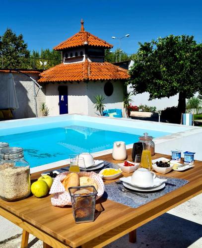 a picnic table with food on it next to a pool at Oryza Guest House& Suites in Coimbra