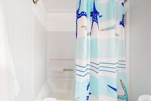 een badkamer met een douchegordijn met blauw en wit bij Brooklyn's Casa Rosa & Hitch Apartment in Ocean City
