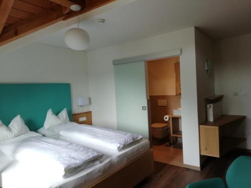 ein Schlafzimmer mit einem weißen Bett und einer grünen Wand in der Unterkunft Pension Runer in Terlan