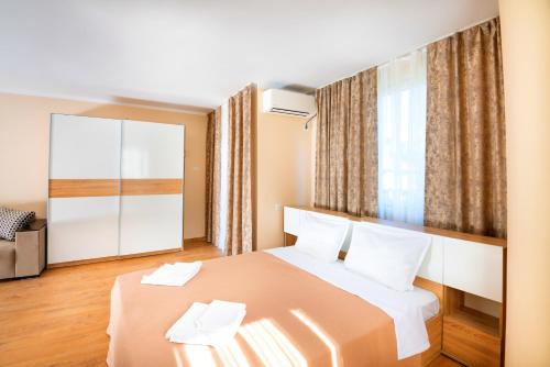 ein Hotelzimmer mit einem Bett und zwei Handtüchern in der Unterkunft House with Garden in Pomorie