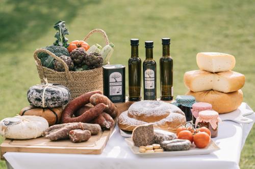 a table with bread and bottles of wine and food at Agroturismo Malbuger Nou Menorca -Adults only- in Mahón