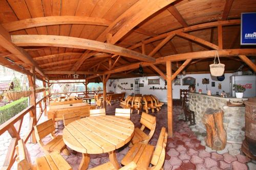 バイレ・ヘルクラネにあるPensiunea El Plazzaの大きな木製テーブルと椅子が備わるレストラン