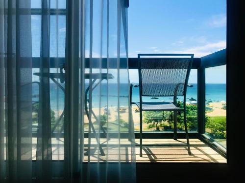 a chair sitting on a balcony looking out at the ocean at Sasa Nor Lamour B&B in Eluan