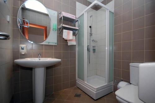 a bathroom with a sink and a shower and a mirror at BMV room for 2-3 with greenery view in Sveti Stefan