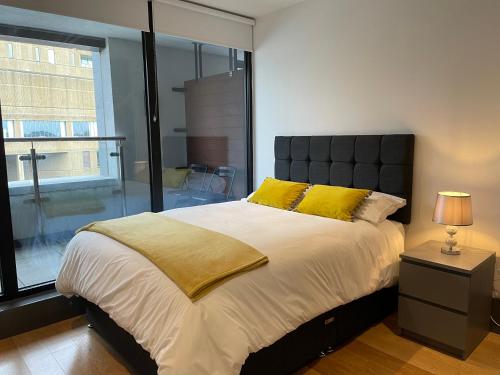 a bedroom with a large bed with yellow pillows at Liverpool City Princes Dock Apartment in Liverpool