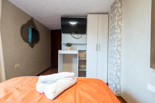 a bedroom with a bed with white towels on it at INTI KILLA Hostel in Lima