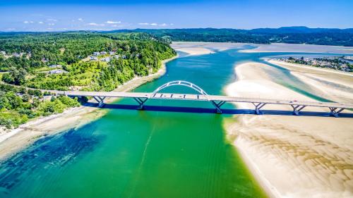 a bridge over the water next to a beach at Windsong Hideaway in Waldport