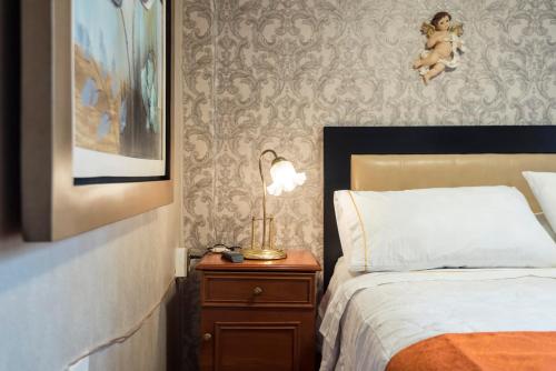 a bedroom with a bed and a nightstand with a lamp at INTI KILLA Hostel in Lima
