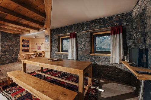 a living room with a wooden table and a tv at Kazbegi Hut in Kazbegi