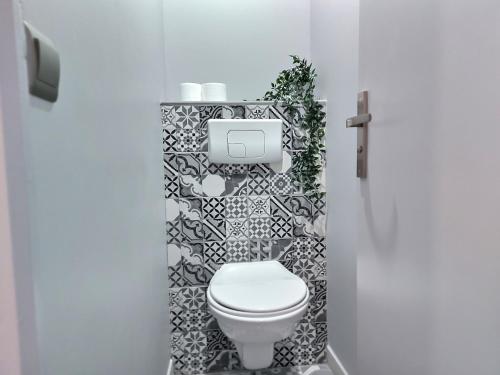 uma casa de banho com WC e azulejos pretos e brancos. em La villageoise em Dammartin-en-Goële