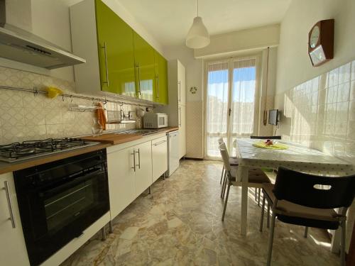 a kitchen with a table and a kitchen with green cabinets at Apartment via Antica Romana in Sestri Levante