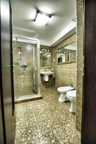 a bathroom with two toilets and a shower and a sink at Mario Apartamente - Romantic Mamaia in Mamaia