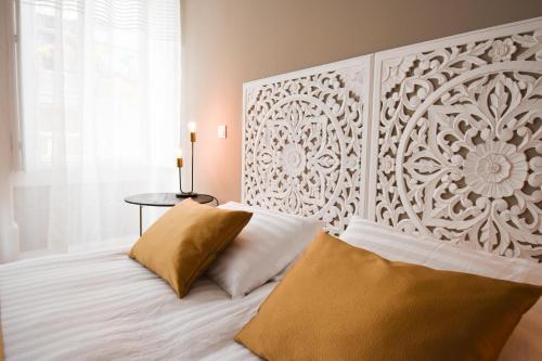 a bedroom with a white bed with a large headboard at Charme 19 in Coimbra