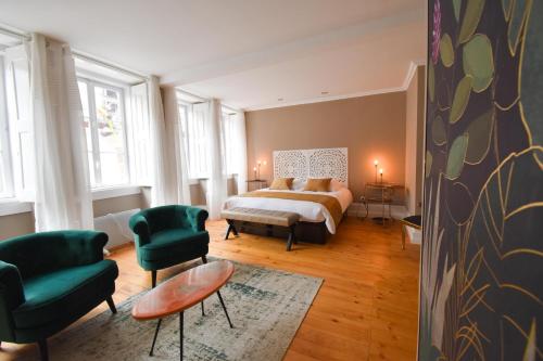 sypialnia z łóżkiem i 2 zielonymi krzesłami w obiekcie Charme 19 w mieście Coimbra