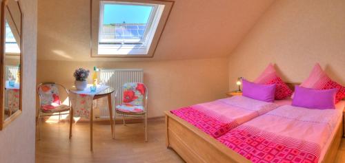 - une chambre avec un lit, une table et des chaises dans l'établissement Weingut und Pension Markus Kochems, à Mesenich