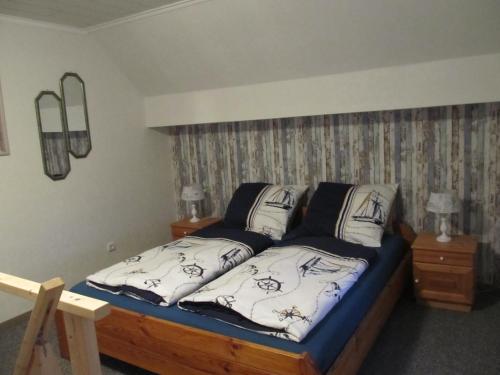 - une chambre avec un lit et 2 oreillers dans l'établissement Landhaus beim See, à Großheide