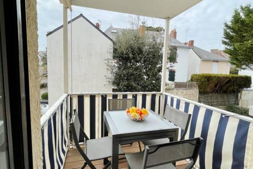 - une table et des chaises sur un balcon avec un bol de fruits dans l'établissement APPARTEMENT LA BAULE 5 PERS A 50 M DE PLAGE, à La Baule