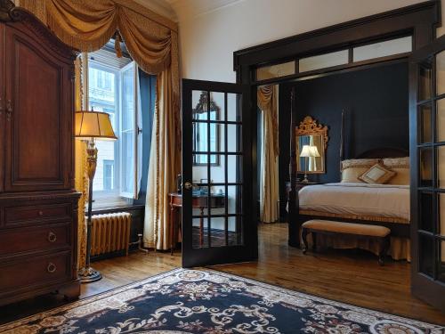 a bedroom with a bed and a glass door at Le Clos Saint-Louis in Quebec City