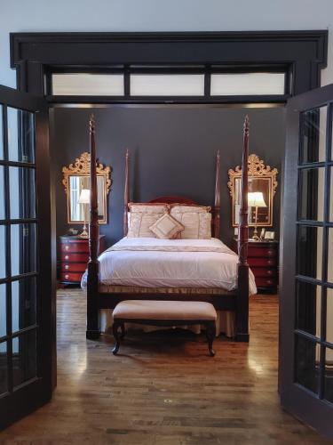 a bedroom with a canopy bed and a bench at Le Clos Saint-Louis in Quebec City
