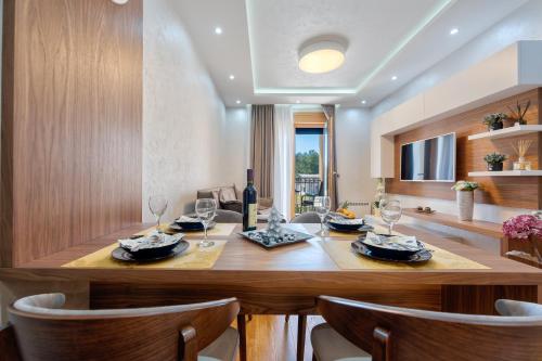 a dining room with a table with wine glasses at Lux Apartman Lea - Vila Esla 1 in Zlatibor