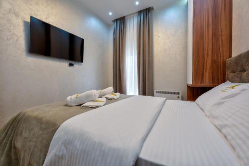 a bedroom with two beds and a flat screen tv at Lux Apartman Lea - Vila Esla 1 in Zlatibor