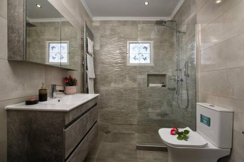 uma casa de banho com um chuveiro, um lavatório e um WC. em Seaview Cottage - Calmare em Petrití