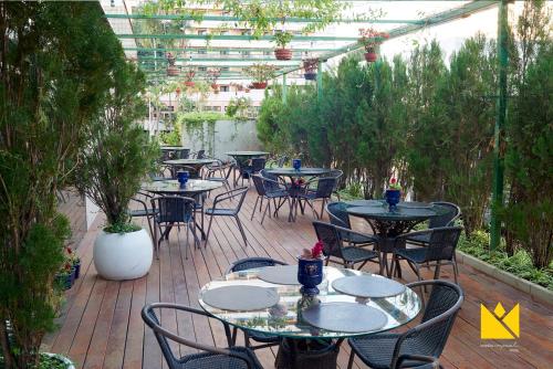 een patio met tafels en stoelen in een tuin bij Brasília Imperial Hotel e Eventos in Brasilia