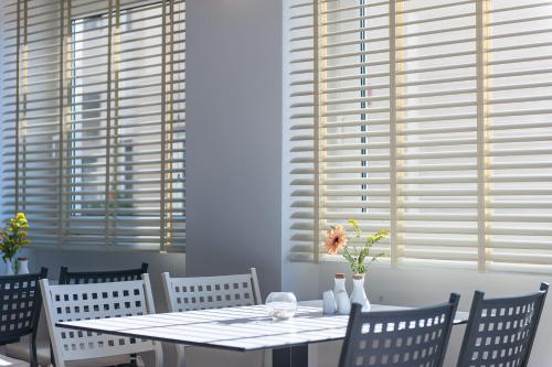 a dining room with a table and chairs and windows at Corinna Mare in Kalamaki Chanion